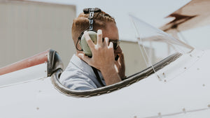 pilot in open cockpit aircraft with headset