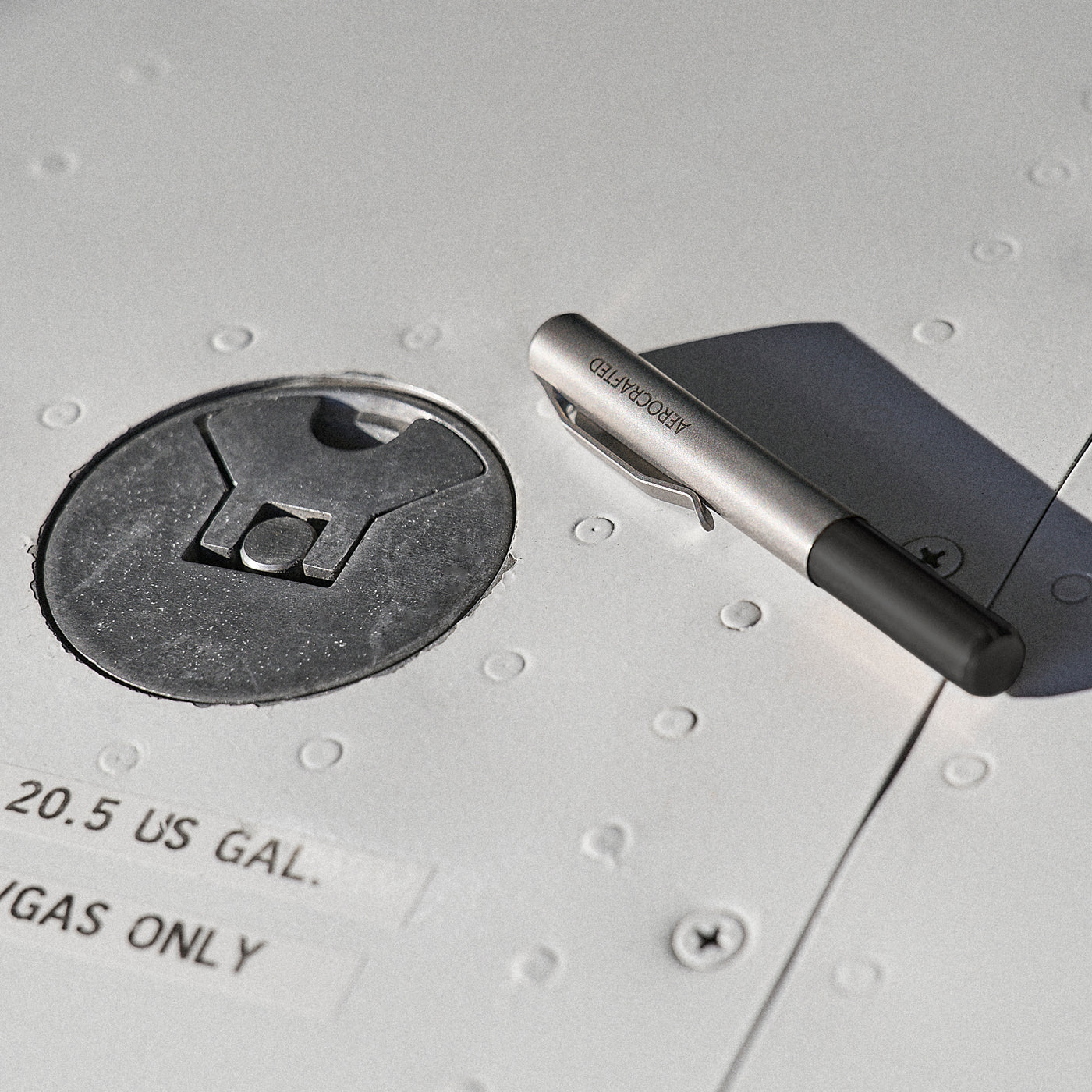 A closed contrail pocket pen laying on an airplane wing is a titanium edc pen designed by aerospace engineers at aerocrafted in California #material_titanium-ultem
