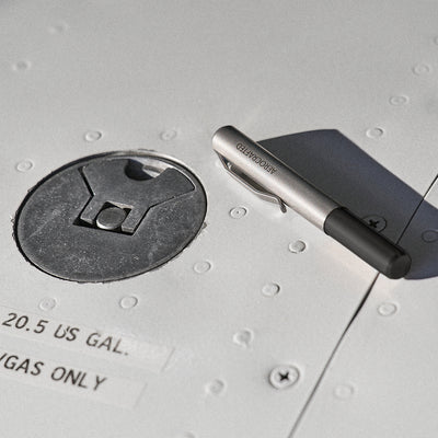 A closed contrail pocket pen laying on an airplane wing is a titanium edc pen designed by aerospace engineers at aerocrafted in California #material_titanium-ultem