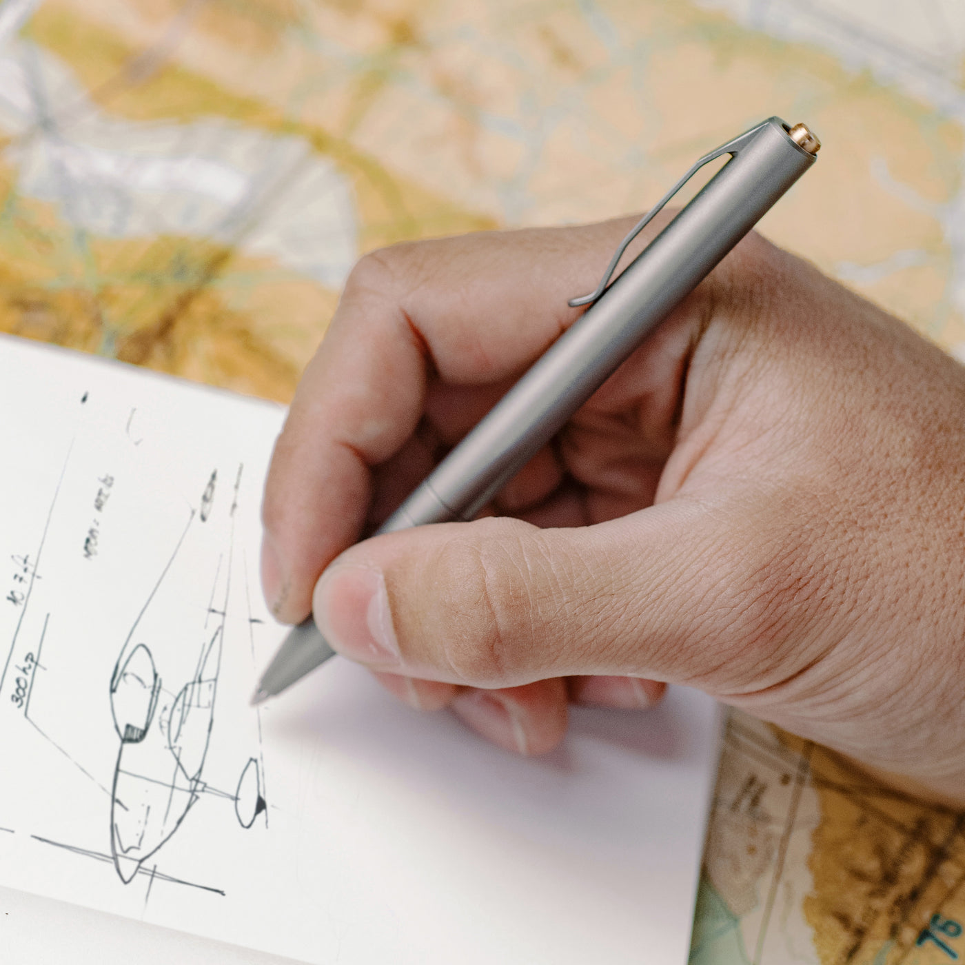 Titanium pen made by aerospace engineers drawing an airplane in a notebook holds a parker refill and is one of the best titanium pens on the market #material_titanium-bronze