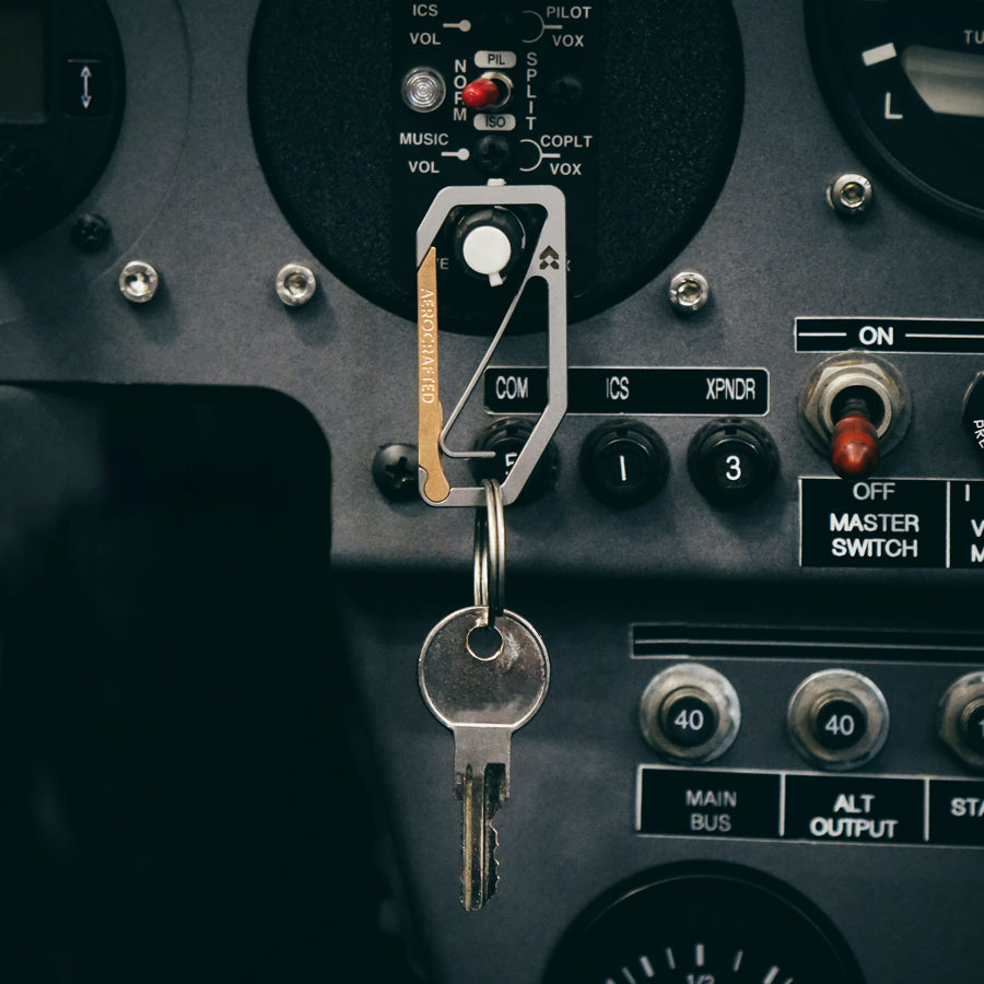 aerocrafted uplock key edc carabiner is made out of titanium and bronze hanging with a keyring attached to the keychain carabiner is designed by aerospace engineers and made in the usa #material_titanium-bronze