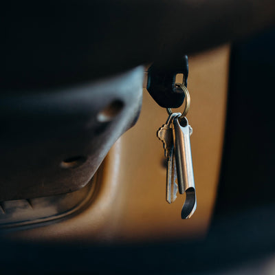 aerocrafted's edc bottle opener hanging on key ring for as a titanium edc bottle opener inside a car #material_titanium
